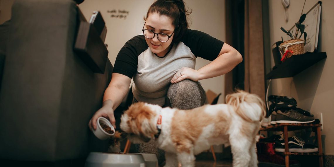 Woman Feeding Dog in Home